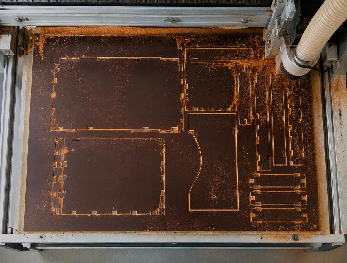 Freshly cut plywood sheet on the CNC router, with every part of the pack